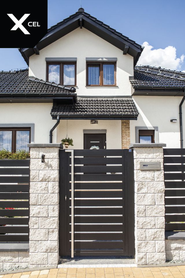 a white house with black gates and windows