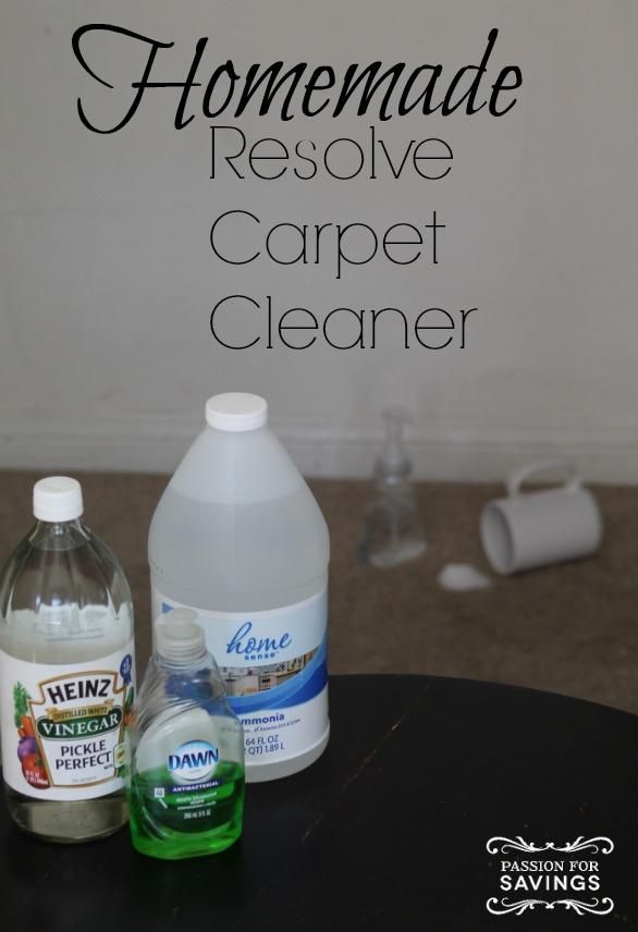 two bottles of carpet cleaner sitting on top of a black table next to a white wall