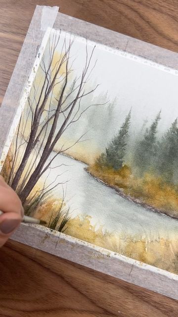 someone is painting a landscape with watercolors