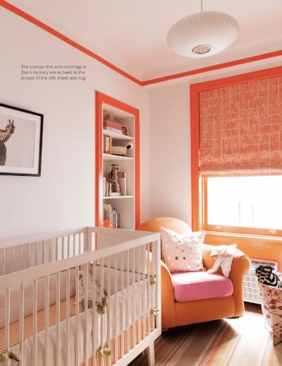 a baby's room with an orange chair and white crib