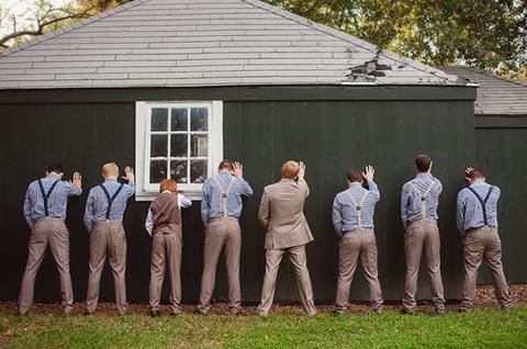 a group of men standing next to each other in front of a building with windows