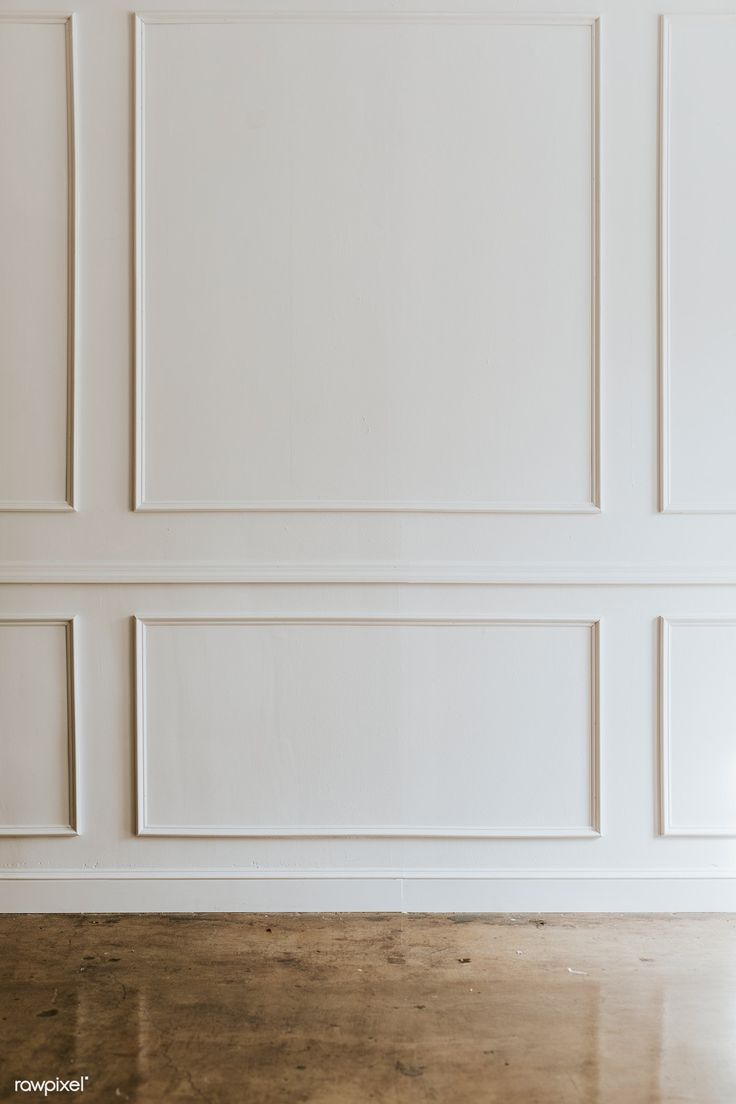 an empty room with white paneled walls and wood flooring is pictured in this image