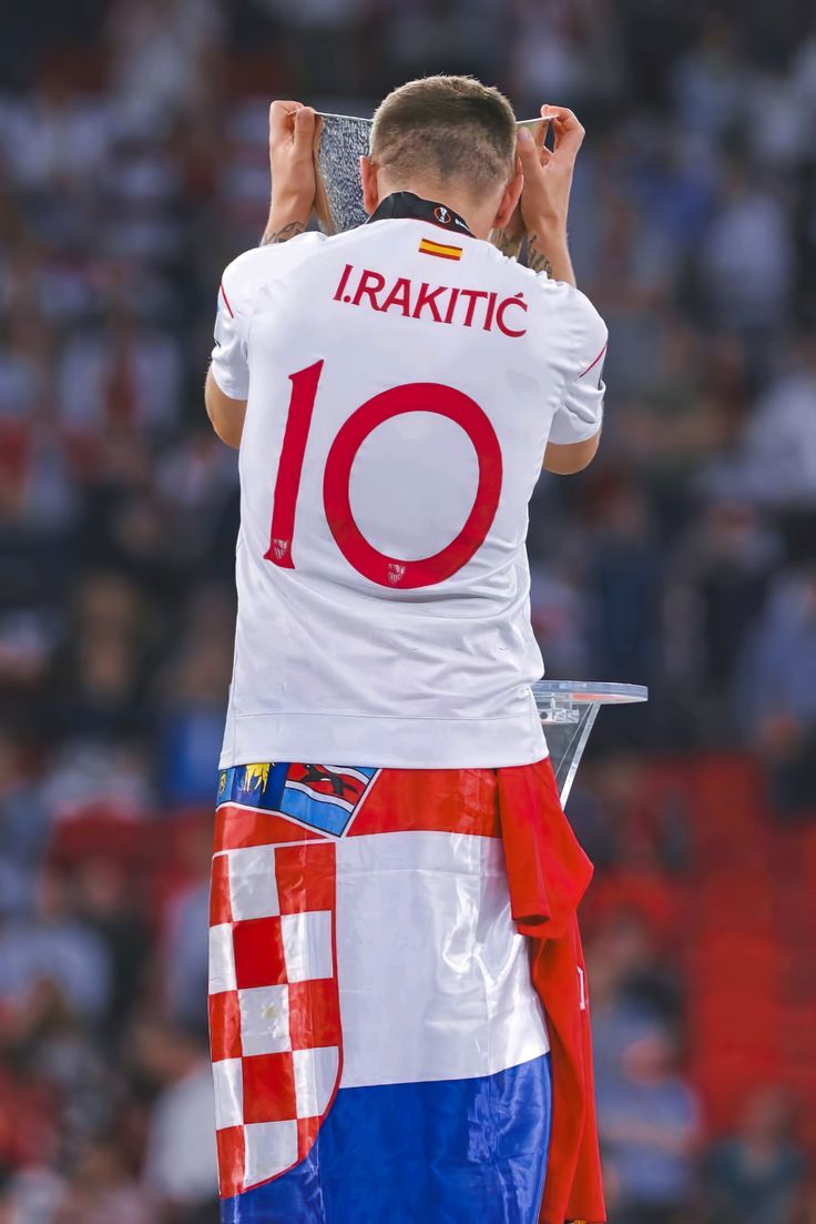 a man holding up a trophy in front of a crowd