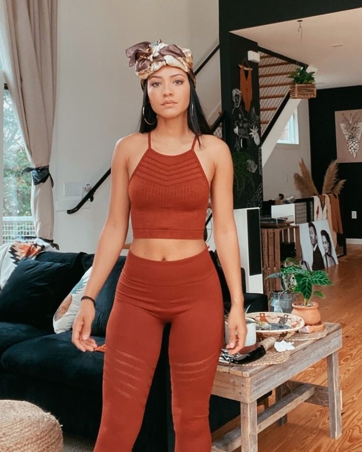 a woman standing in a living room next to a couch