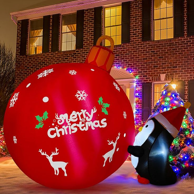 an inflatable christmas ornament with a penguin next to it