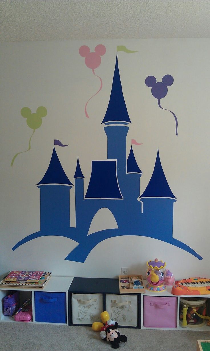 a child's room with a castle painted on the wall and toys in bins