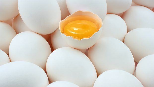 an egg shell is in the middle of several white eggs