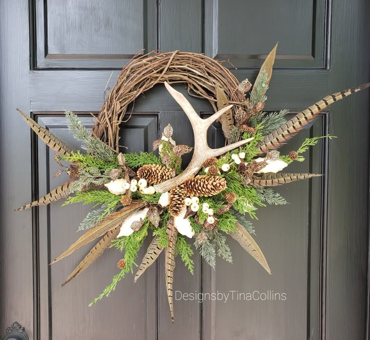 a deer's antler wreath with white flowers and greenery hangs on the front door