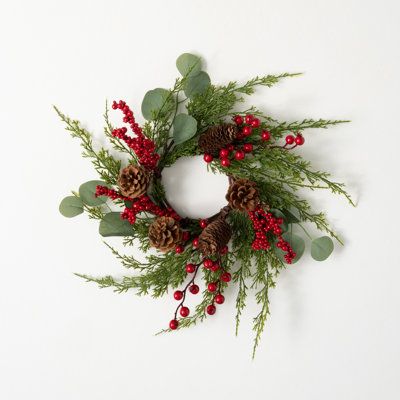 a christmas wreath with pine cones and berries