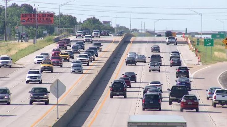 a highway filled with lots of traffic on both sides of the road in front of an exit sign