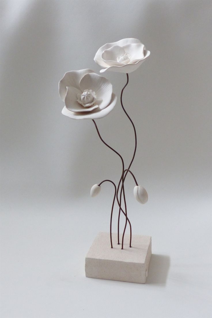 a white sculpture with three flowers on it