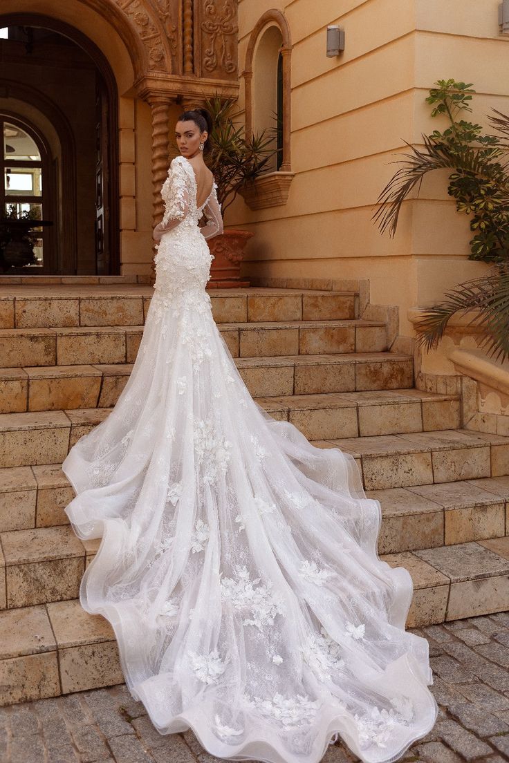 a woman in a wedding dress standing on some steps