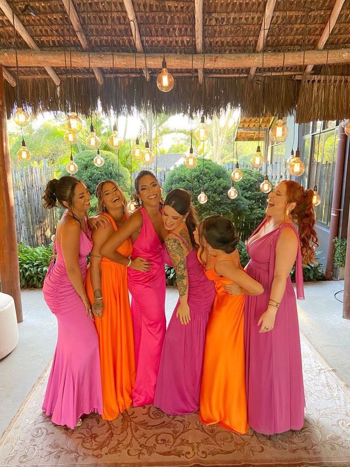 a group of women standing next to each other on a rug in front of a gazebo