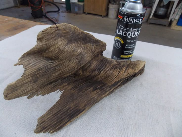 a close up of a piece of wood on a table next to a spray bottle