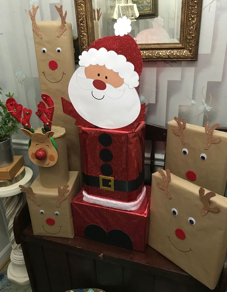 there is a santa clause on top of some boxes with reindeer noses and nose decorations