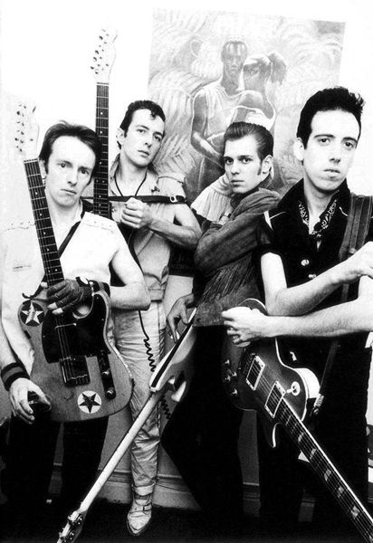 a group of men standing next to each other holding guitars