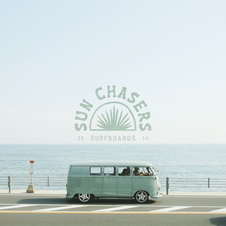 an old vw bus driving down the road by the ocean