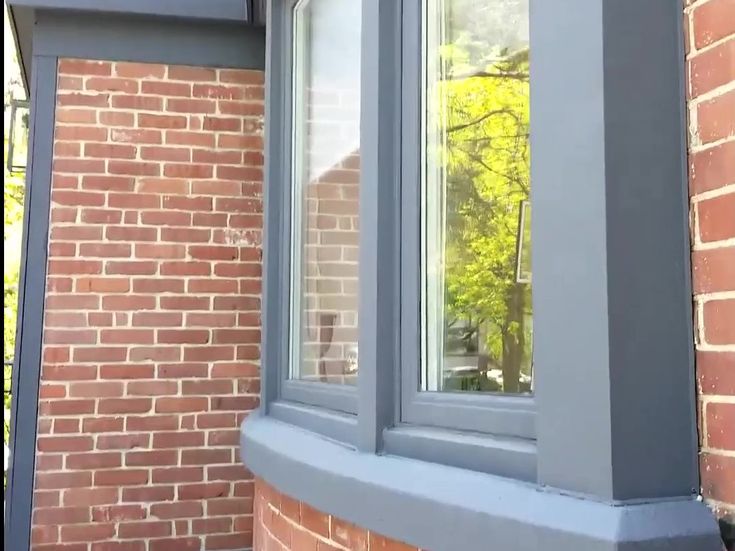 a cat sitting on the ledge of a window