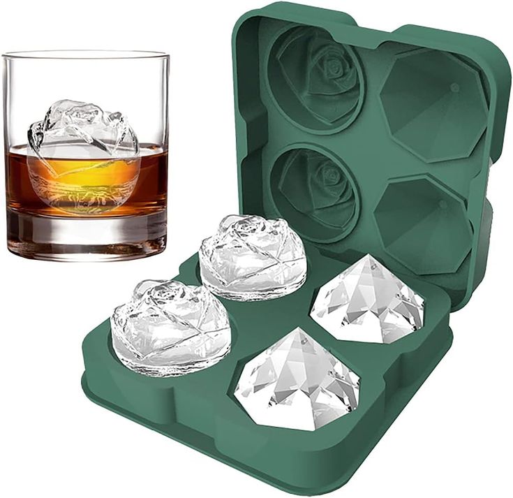 four ice cubes in an ice tray next to a glass of whiskey on a white background