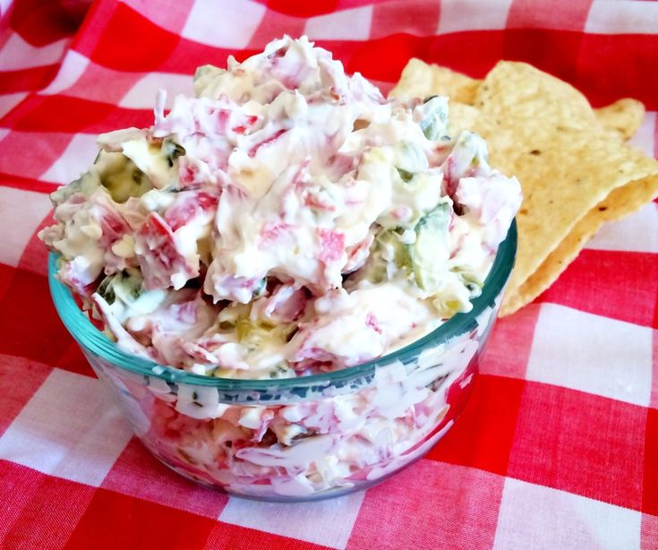 a glass bowl filled with food sitting on top of a red and white checkered table cloth