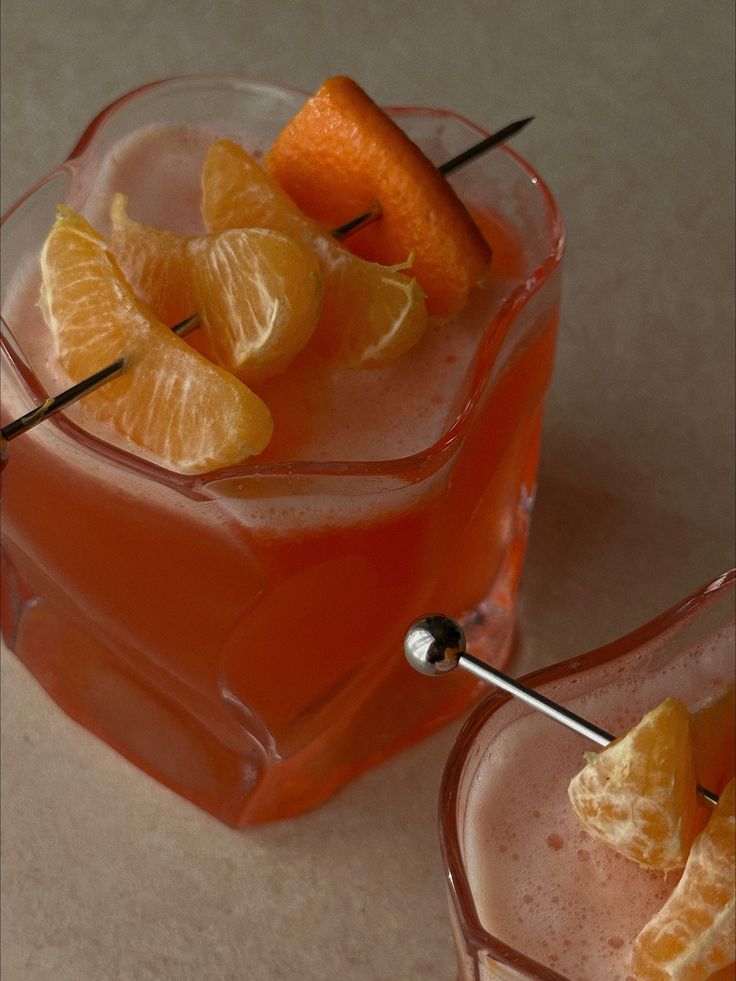 two glasses filled with orange juice and garnish