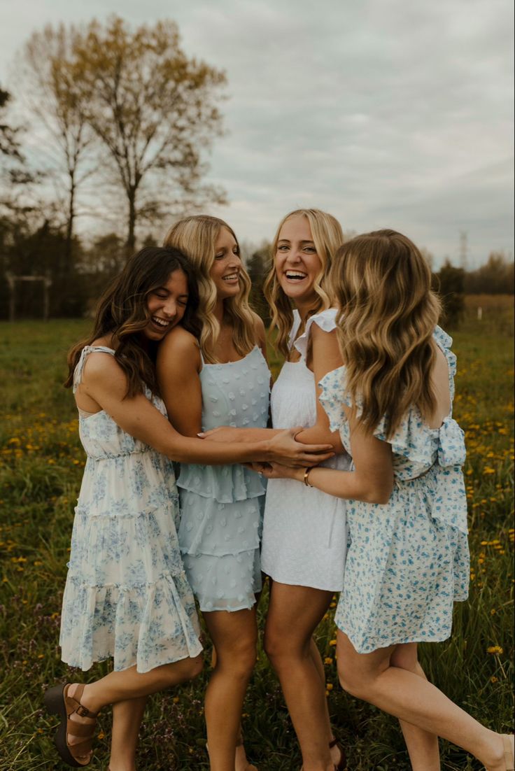 three girls hugging each other in a field