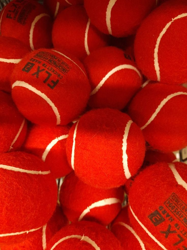 a pile of red tennis balls sitting on top of each other