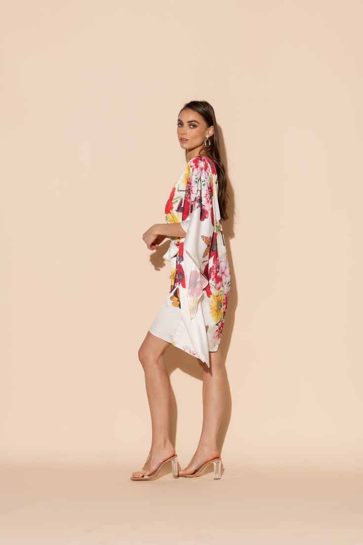 This is one Bouquet you won't want to throw away! Vibrant blooms of flora and fauna adorn this short caftan with tie waist in our signature Polysilk fabric. Dance the night away or lounge in luxe - the occasions are endless with this beautiful, blossoming statement piece. Machine washable for ease of care. Silk V-neck Summer Robe, Chic Floral Print Kimono For Brunch, Silk Floral Print Kaftan For Beach Cover-up, Spring Beach Cover-up Kaftan With Tie Waist, Summer Silk Lounge Robe, Spring Floral Print Chic Kaftan, Summer Silk Loungewear Robe, Chic Floral Print Spring Kaftan, Chic Floral Print Kimono For Daywear