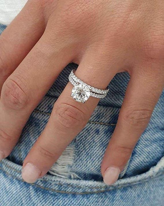 a close up of a person's hand with a ring on their finger and an engagement band