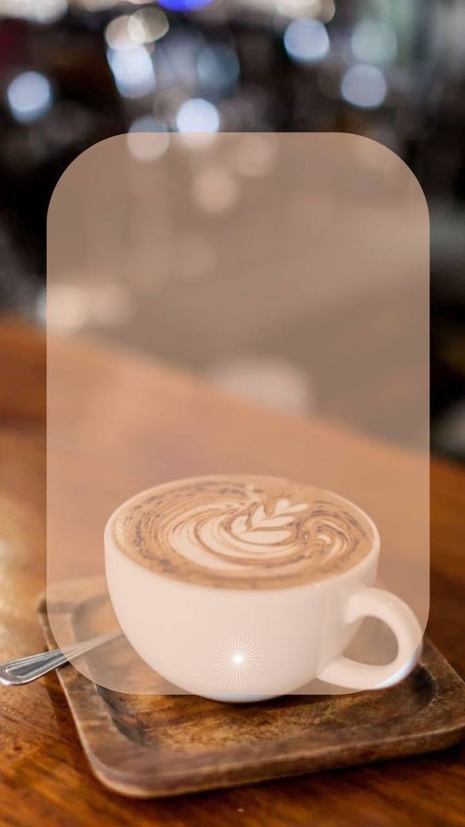 a cappuccino is sitting on a wooden table