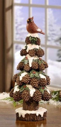 a christmas tree made out of pine cones with a bird sitting on top of it