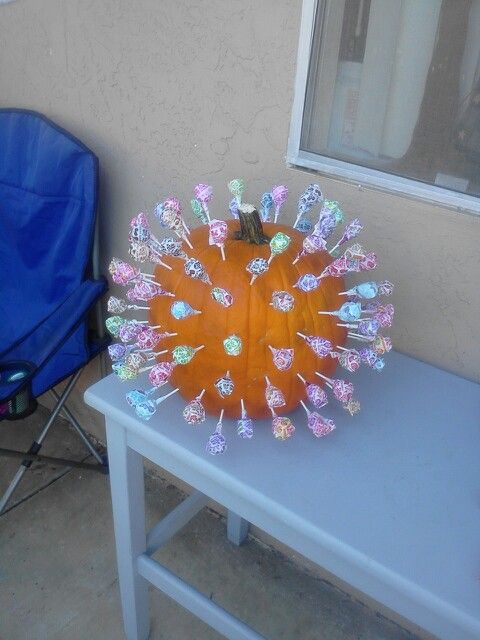 an orange vase sitting on top of a white table next to a blue lawn chair