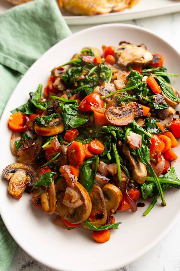 a white plate topped with mushrooms and veggies