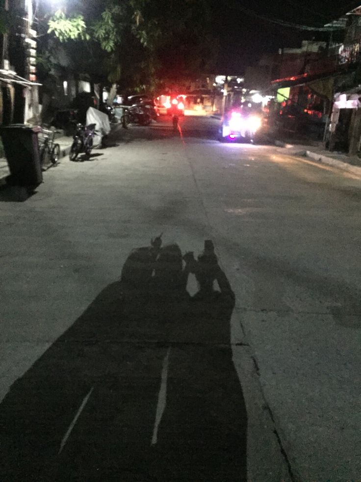 a motorcycle parked on the side of a street next to a firetruck at night