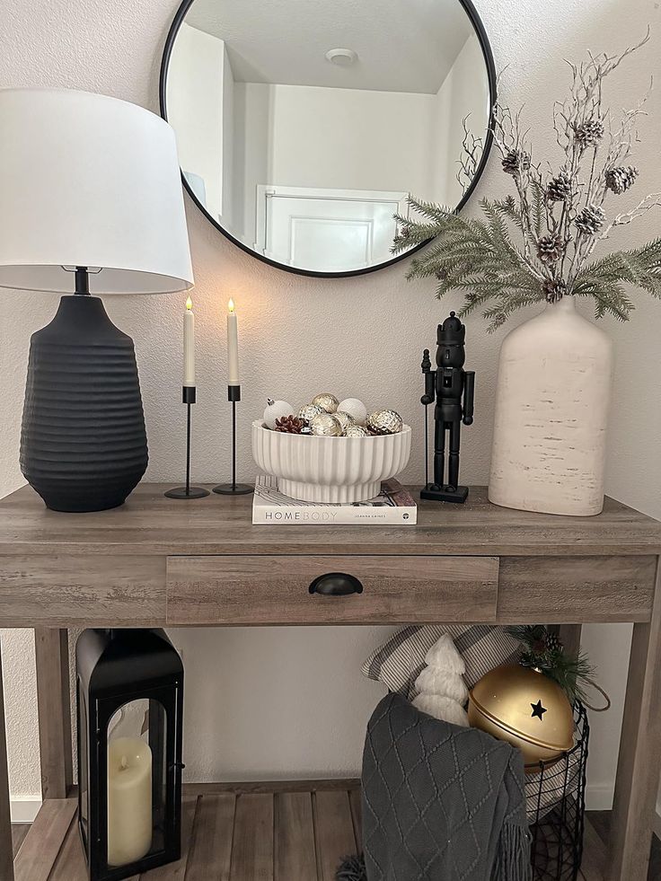 a wooden table topped with a mirror next to a lamp