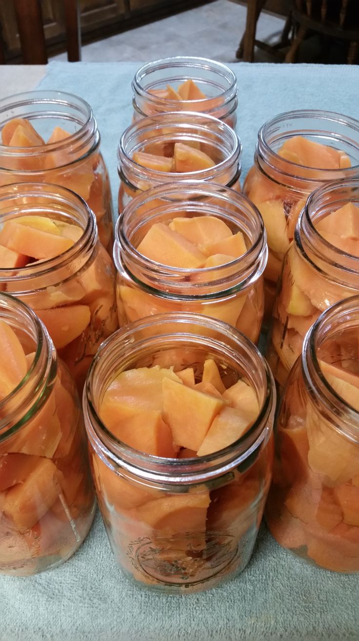 there are many jars filled with diced fruit on top of a blue table cloth