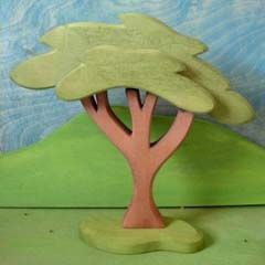 a wooden sculpture of a tree in front of a painting