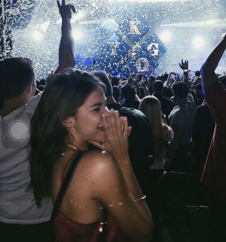 a woman standing in front of a crowd at a concert