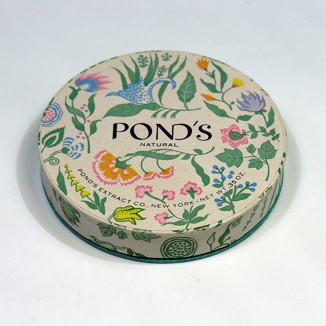 a round box with flowers and birds painted on the lid is sitting on a white surface