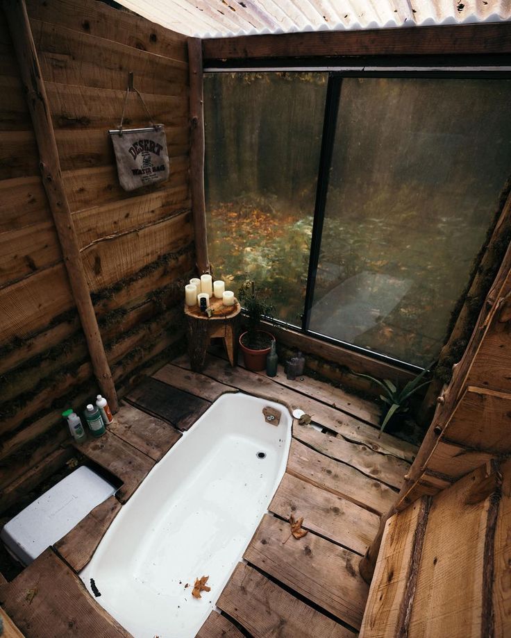 an old bathtub sits in the corner of a rustic bathroom with wooden walls and flooring