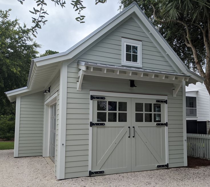 a gray garage with two doors and windows