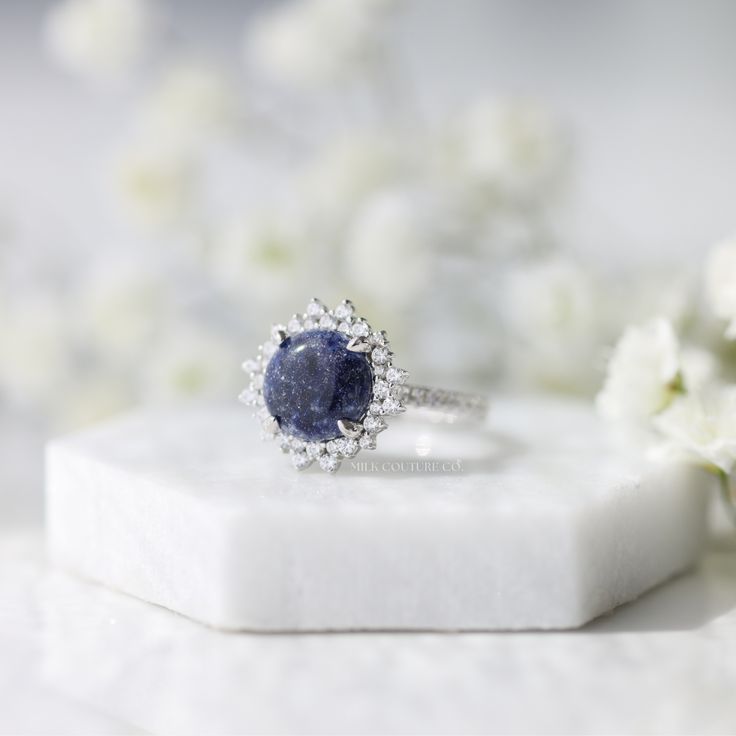 The Stella ring is a work of art, intricately designed to resemble a star in the night sky. The round center keepsake stone is the centerpiece of the design, and it sits nestled in the center of the ring, surrounded by a halo of smaller stones that accentuate its beauty. Estelle means star in Italian, and this ring is named in honor of my late grandma Estelle. She was a woman who truly shined like a star, with the most unforgettable smile and laugh! Luxury Cluster Sapphire Ring With Center Stone, Luxury Cluster Ring With Round Cut Gemstone, Luxury Sapphire Ring With Round Stone, Exquisite Round Gemstones With Halo Setting, Luxury Round Cut Gemstones With Center Stone, Luxury Round Cut Center Stone Gemstones, Timeless Sapphire Ring Gift, Luxury Sapphire Gemstone Cluster Ring, Luxury Sapphire Cluster Ring With Gemstones