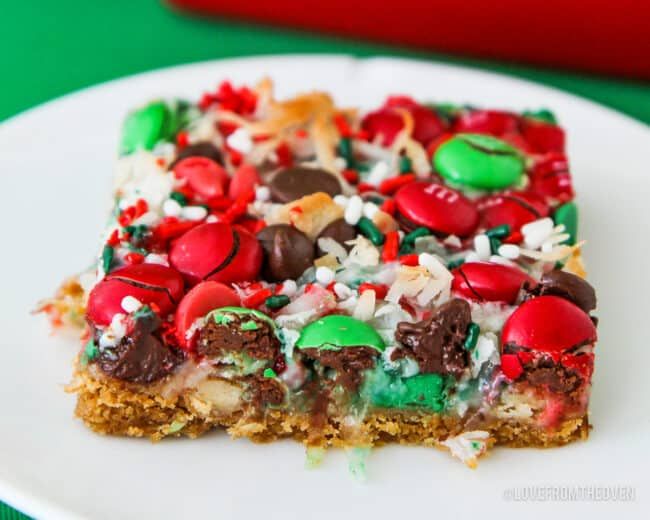 a white plate topped with a slice of cake covered in m & m candies