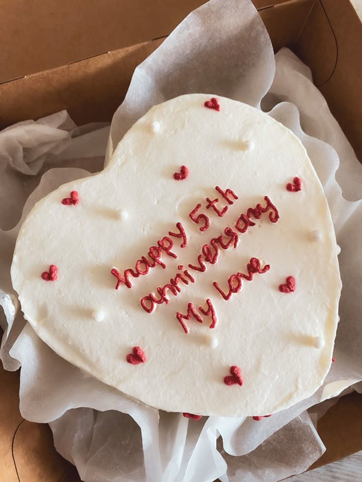 a heart shaped cake in a box with writing on it that says happy 5th anniversary my love