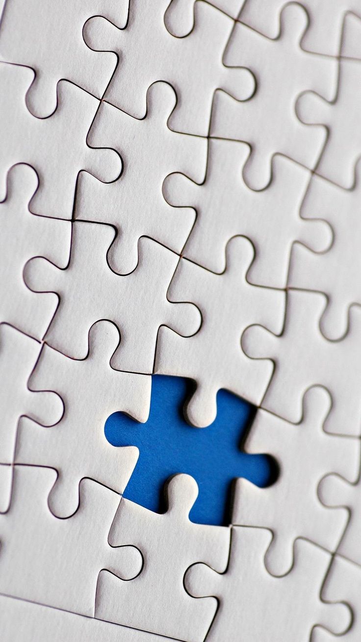 a blue piece of puzzle sitting on top of a white surface