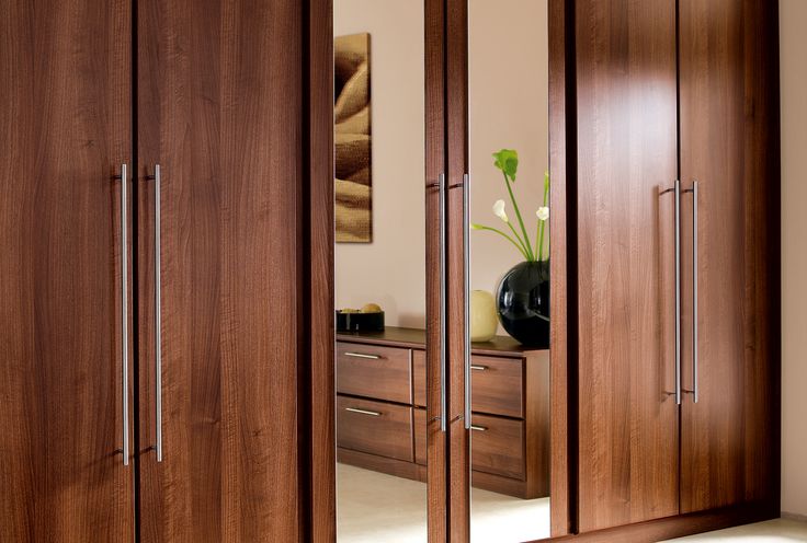 a large wooden closet with mirrored doors and drawers