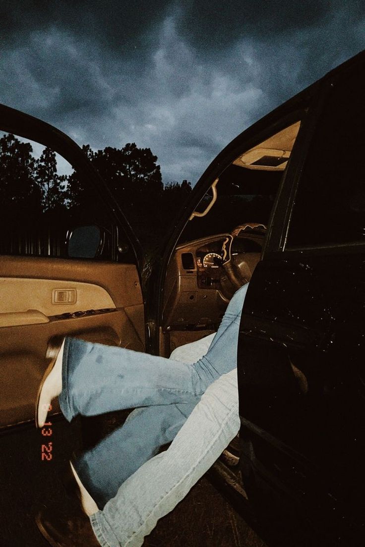 a person laying on the back of a car