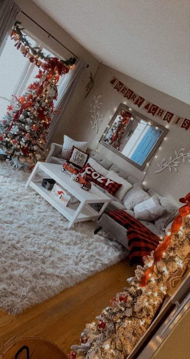 the living room is decorated for christmas with red and white decorations on the walls, along with a large tree