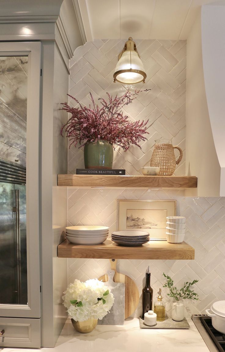 the shelves in this kitchen are filled with dishes and vases on top of them