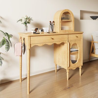 a wooden desk sitting next to a chair and potted plant on top of a hard wood floor